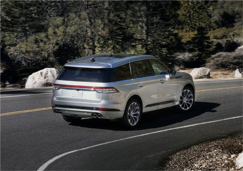 A 2023 Lincoln Aviator® Grand Touring model is shown being driven on a tight turn of a mountain road | Performance Lincoln Bountiful in Bountiful UT